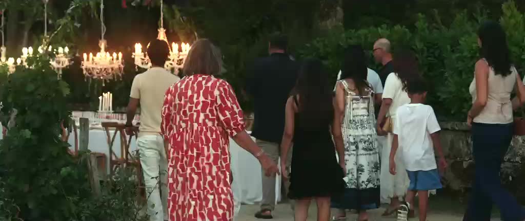 Invités arrivant sous les lustres du jardin